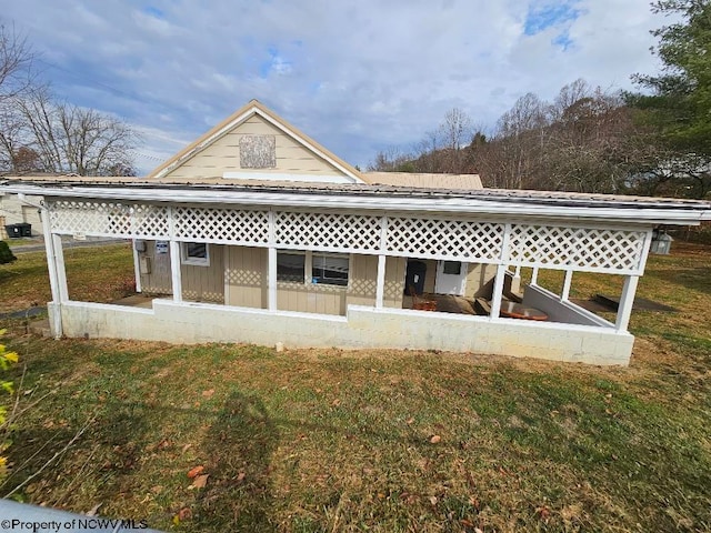 rear view of house featuring a lawn