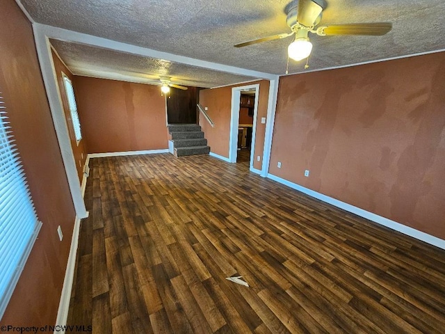 unfurnished room with ceiling fan, dark hardwood / wood-style floors, and a textured ceiling