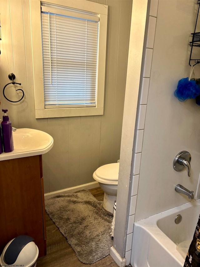 full bathroom with toilet, vanity, wood-type flooring, and  shower combination