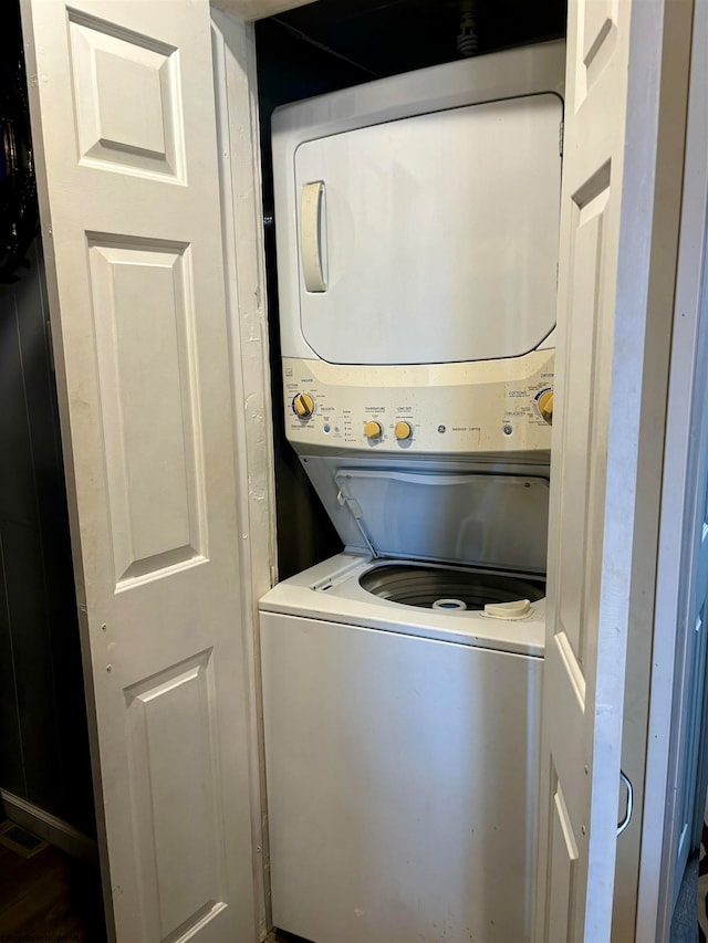 clothes washing area featuring stacked washer and clothes dryer