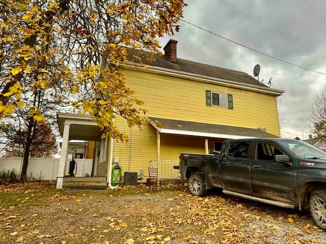 back of property with central AC and a porch