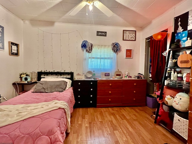 bedroom featuring ceiling fan, light hardwood / wood-style floors, and crown molding