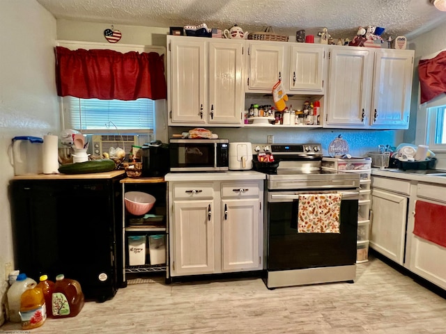 kitchen featuring white cabinets, a textured ceiling, and stainless steel appliances