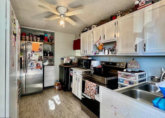 kitchen featuring stainless steel appliances, light hardwood / wood-style floors, ceiling fan, a textured ceiling, and white cabinets