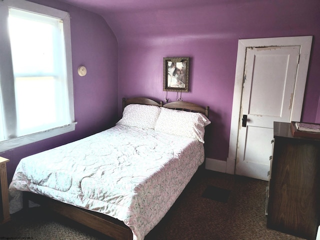 bedroom with lofted ceiling and dark carpet