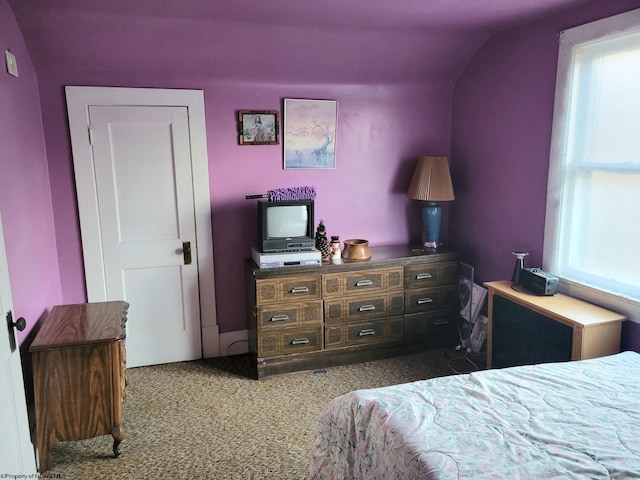 carpeted bedroom with lofted ceiling