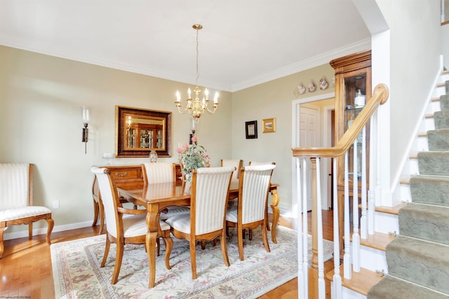 dining area featuring light hardwood / wood-style floors, crown molding, and an inviting chandelier