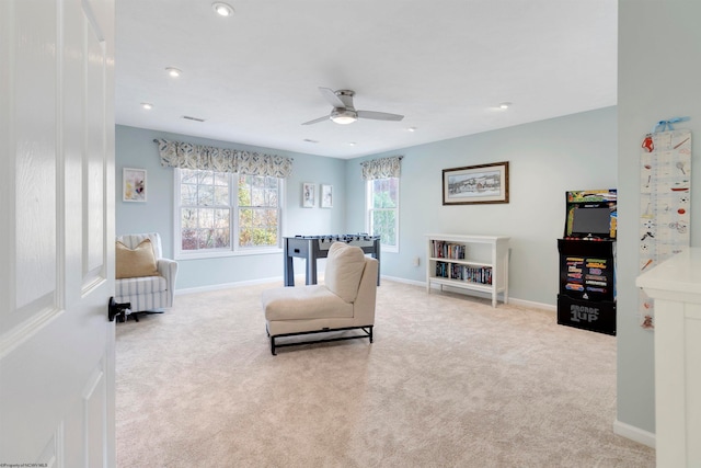 sitting room featuring light carpet and ceiling fan