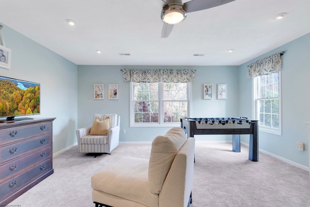 recreation room featuring ceiling fan, light colored carpet, and a healthy amount of sunlight