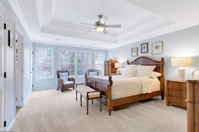 bedroom with crown molding, light carpet, ceiling fan, and a raised ceiling