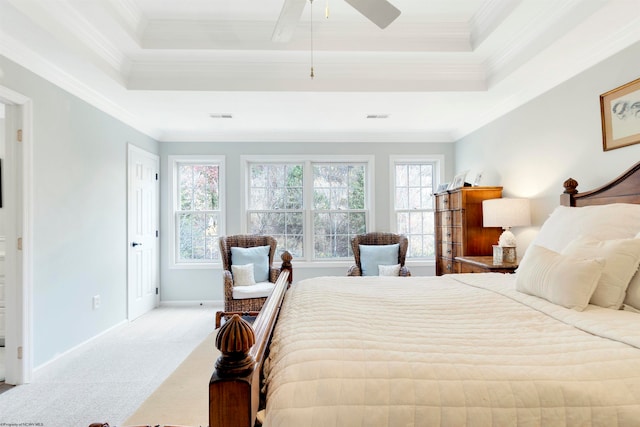 carpeted bedroom with ceiling fan, crown molding, and a tray ceiling