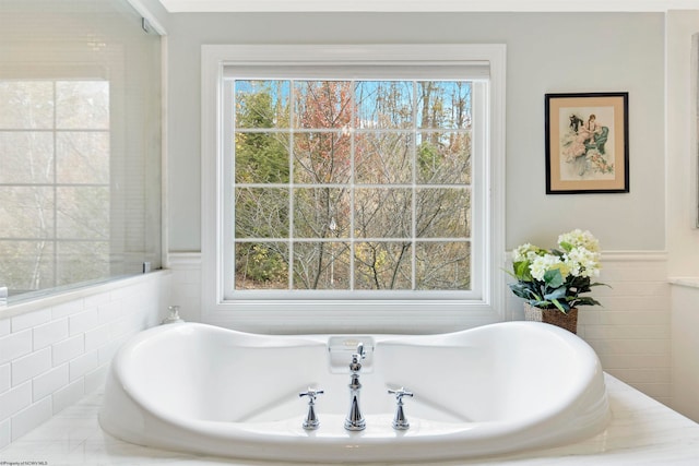 bathroom featuring a tub to relax in and tile walls