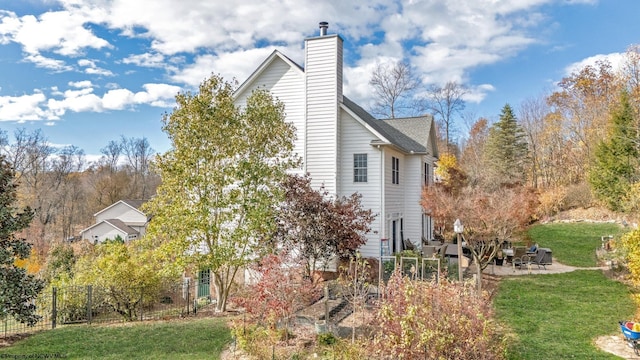 view of side of home featuring a lawn and a patio