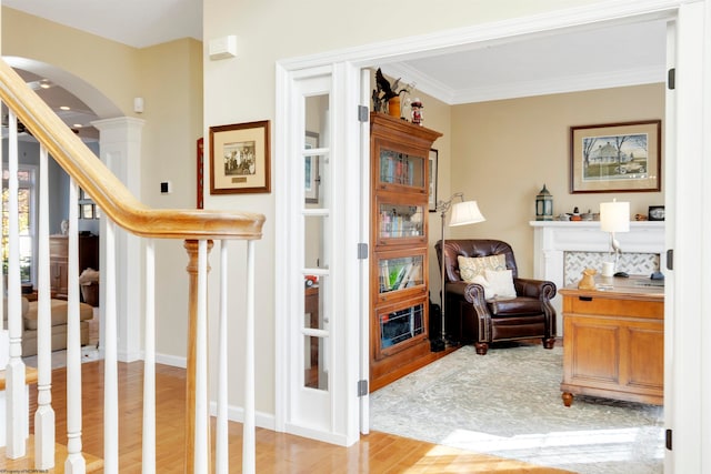 living area featuring light wood-type flooring and crown molding