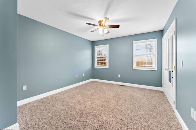 carpeted spare room with ceiling fan