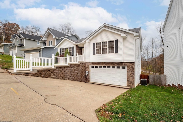 view of front facade featuring a garage, central AC unit, and a front yard