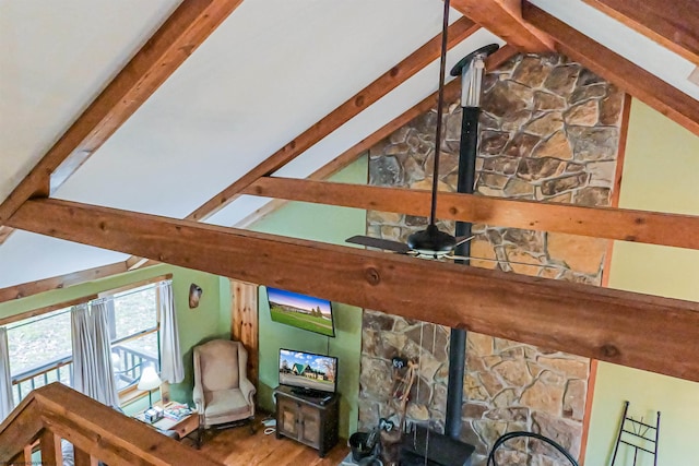 room details with wood-type flooring, beam ceiling, and a wood stove