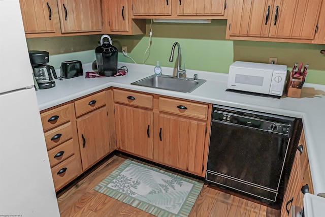 kitchen featuring white appliances, sink, and light hardwood / wood-style flooring