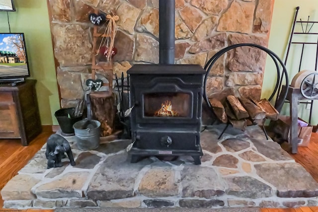 interior details featuring hardwood / wood-style floors and a wood stove