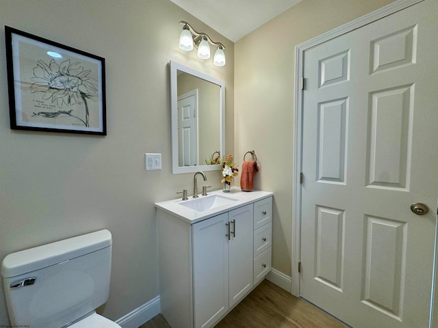 bathroom with hardwood / wood-style floors, vanity, and toilet