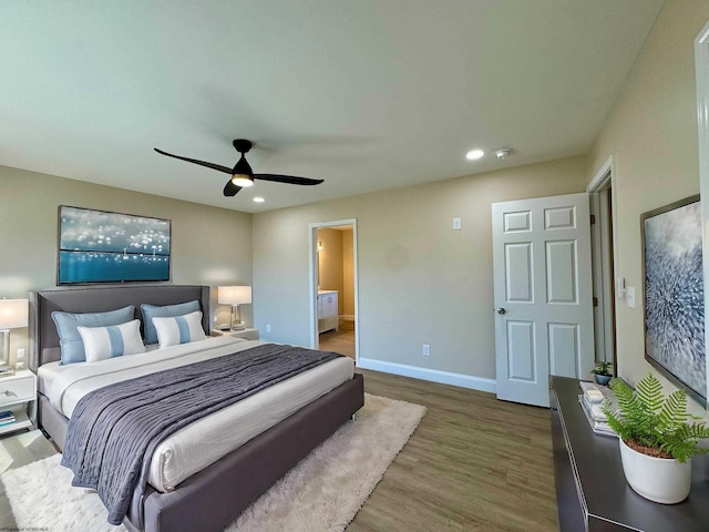 bedroom featuring connected bathroom, hardwood / wood-style flooring, and ceiling fan