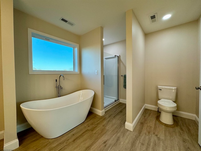 bathroom featuring toilet, plus walk in shower, and hardwood / wood-style floors