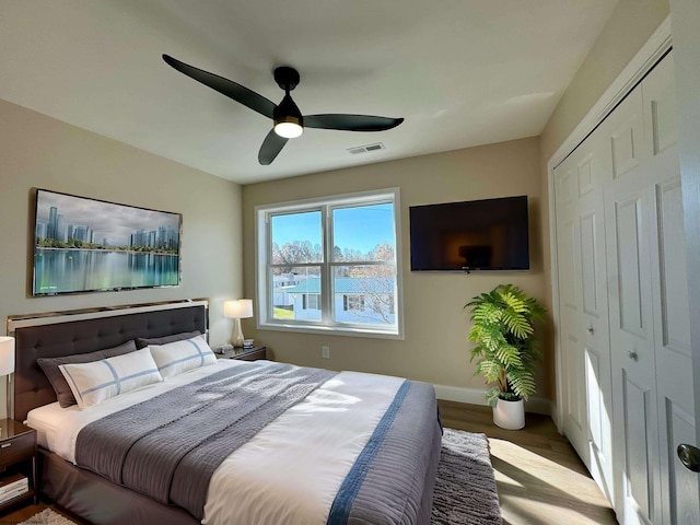 bedroom featuring hardwood / wood-style flooring, ceiling fan, and a closet