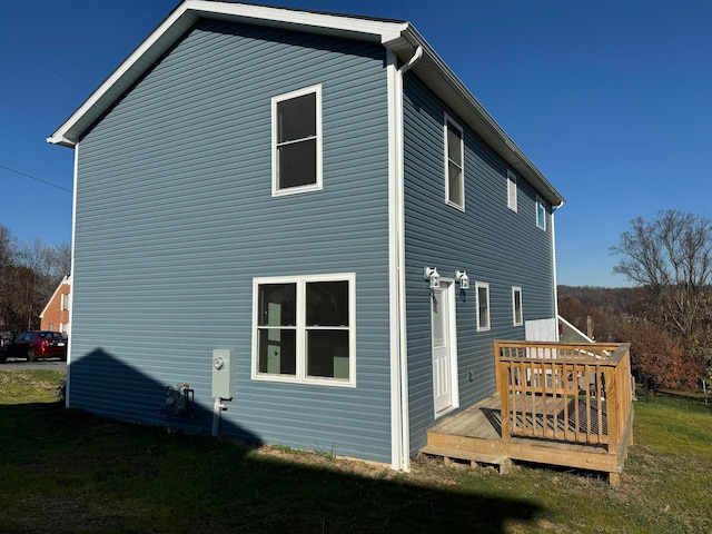 rear view of property with a yard and a deck