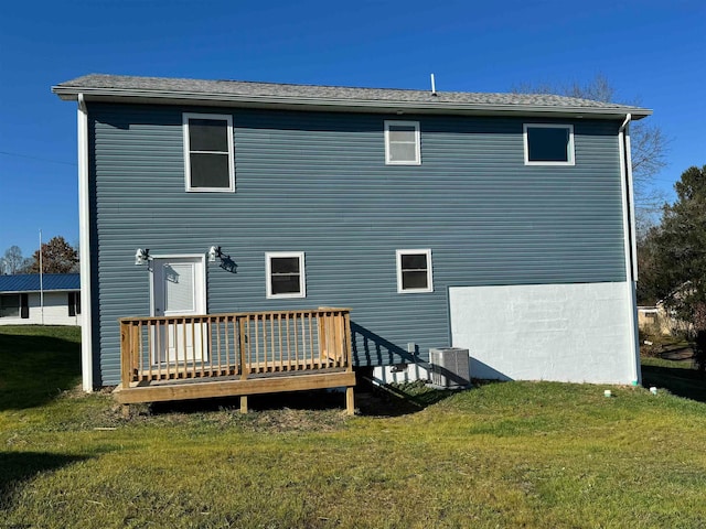 back of property with a deck, central AC, and a yard