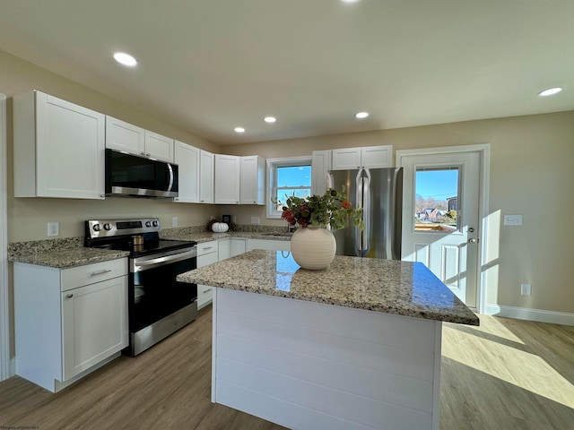 kitchen with white cabinetry, stainless steel appliances, and a healthy amount of sunlight