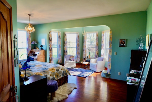 bedroom with a chandelier and dark hardwood / wood-style floors