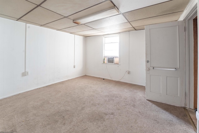 basement with a drop ceiling, light carpet, and cooling unit