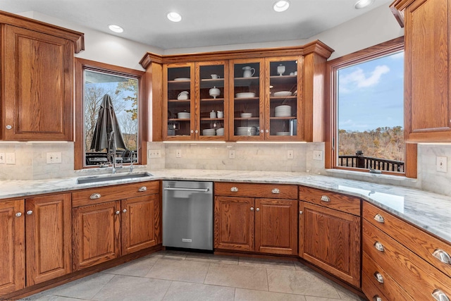 kitchen featuring light tile patterned floors, light stone countertops, sink, and tasteful backsplash