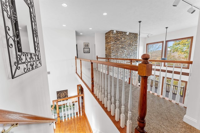 stairs with track lighting and wood-type flooring