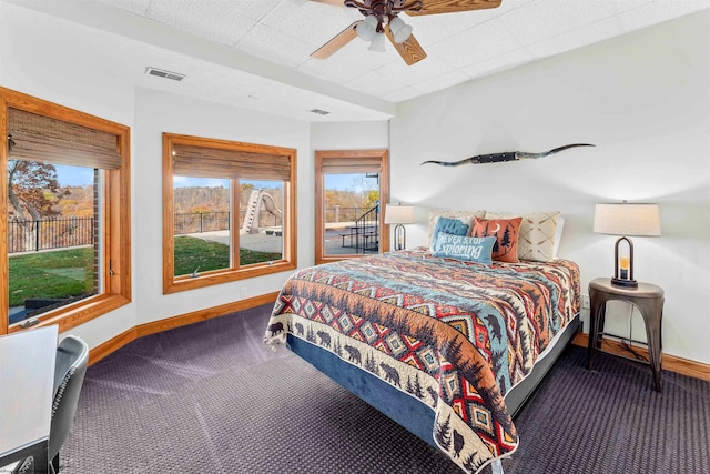 bedroom with ceiling fan and dark colored carpet