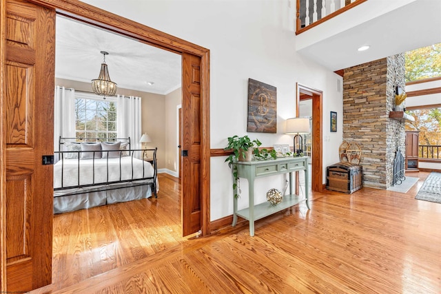 hallway featuring light hardwood / wood-style flooring, a notable chandelier, and crown molding