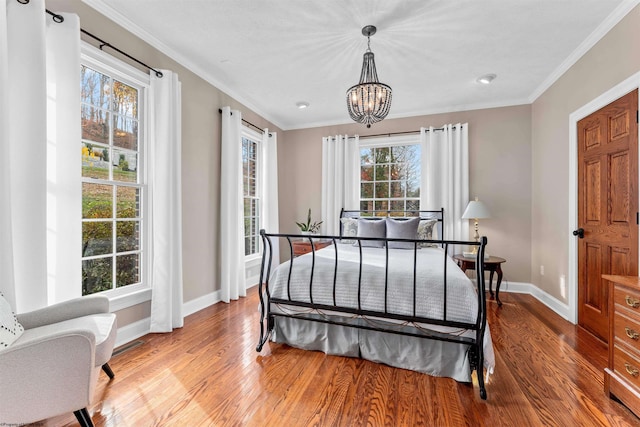 bedroom with a chandelier, light hardwood / wood-style floors, and crown molding