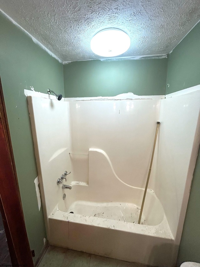 bathroom with a bath and a textured ceiling