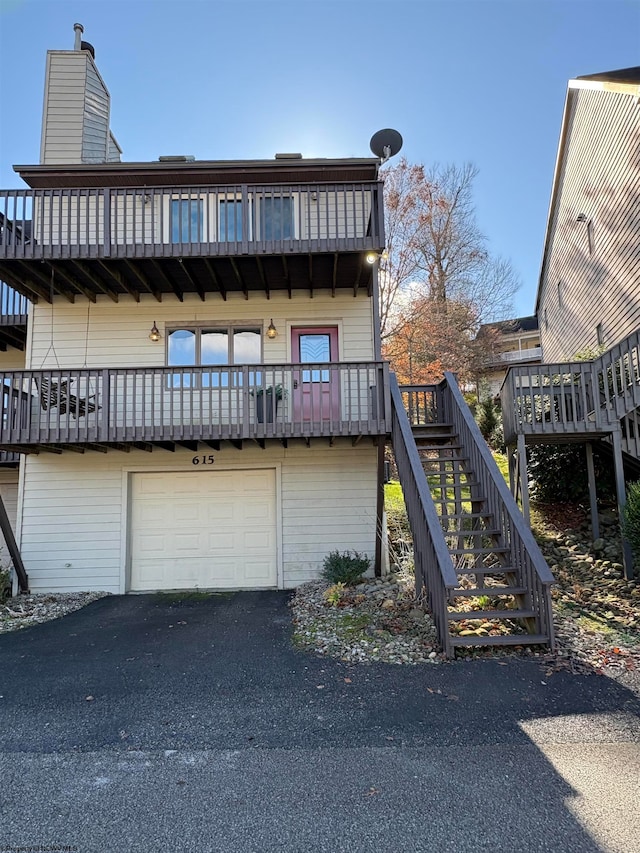 back of house featuring a balcony and a garage