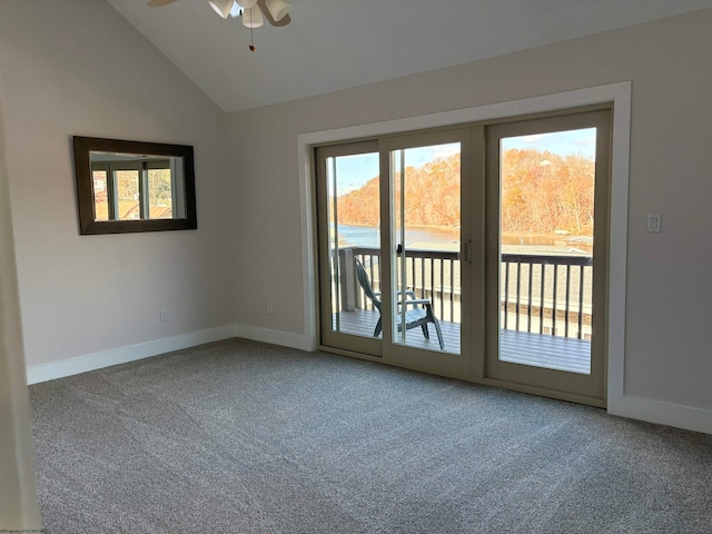 carpeted spare room with ceiling fan, a healthy amount of sunlight, and vaulted ceiling