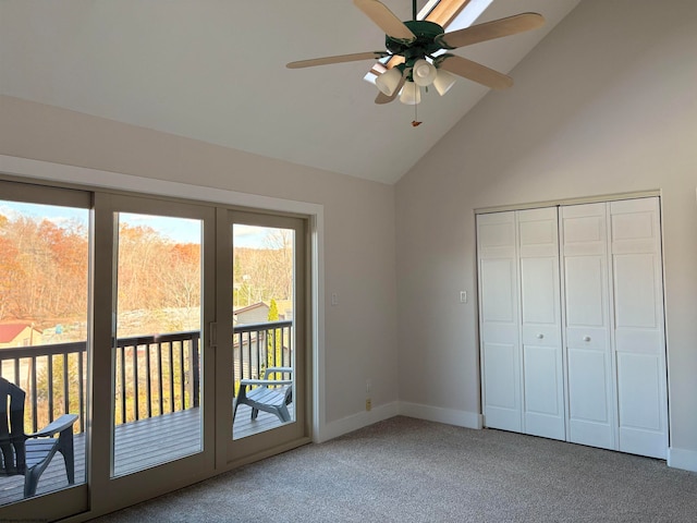 unfurnished bedroom featuring carpet flooring, access to outside, lofted ceiling, ceiling fan, and a closet