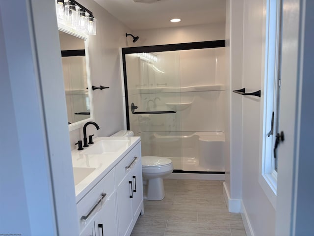 bathroom featuring an enclosed shower, vanity, and toilet