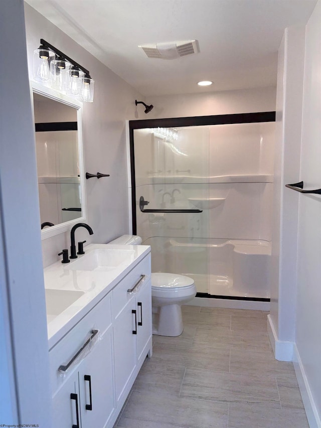 bathroom featuring an enclosed shower, vanity, and toilet