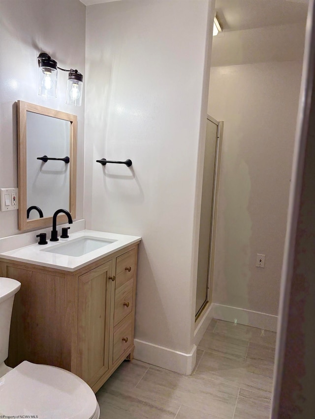 bathroom featuring toilet, vanity, and an enclosed shower