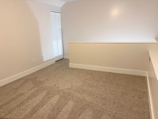 empty room featuring carpet floors and lofted ceiling