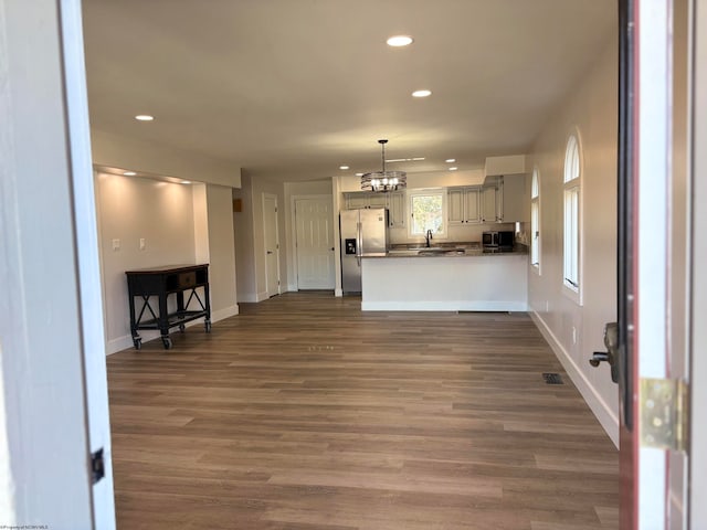 unfurnished living room featuring dark wood-type flooring and a chandelier