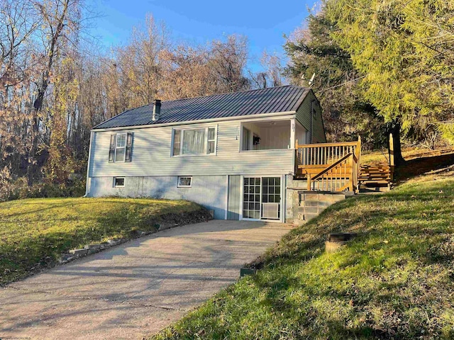 view of front of property with a wooden deck and a front yard