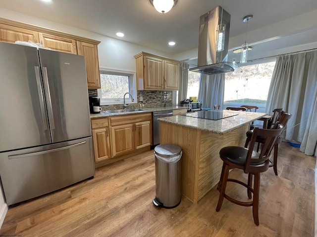 kitchen with sink, appliances with stainless steel finishes, island range hood, a center island, and light wood-type flooring