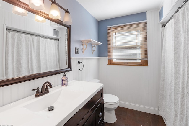 bathroom with toilet, vanity, and wood-type flooring