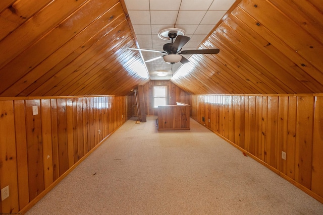 bonus room with wooden walls, light carpet, ceiling fan, and vaulted ceiling